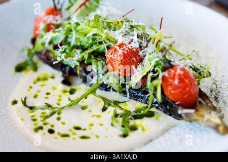 Vegan warm asparagus-broccoli salad with dill aioli, vegan cheese. Delicious healthy vegeterian food served for lunch on a table in modern gourmet Stock Photo