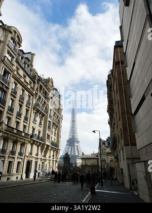 Paris, France - April 30, 2024: Urban Parisian scene featuring the Eiffel Tower framed by surrounding buildings and dramatic skies. Stock Photo