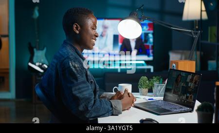 Smiling employee saluting managers, using online videocall to ask for feedback on project progress. Cheerful worker waving hand, greeting coworkers in teleconference meeting, camera A Stock Photo