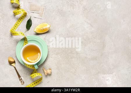 Composition with cup of diet tea, lemon and measuring tape on grunge background. Weight loss concept Stock Photo