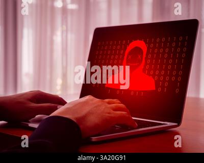Remote access scam, hacker, digital online cyber crime concept. Red scammer icon with binary code, hacked on laptop computer desktop screen, scammers Stock Photo