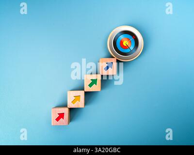 Business growth, goal and success steps, development plan, economic improvement concepts. 3d colorful target dartboard icon on top of wood cubes step Stock Photo
