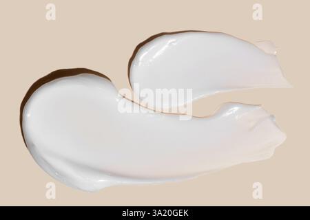 creamy smears of white cosmetic texture close up on beige background skin care concept. Stock Photo