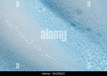 Soap cleanser foam texture. soft shampoo bubbles on blue background. Cosmetic foamy cleansing product swatch Stock Photo