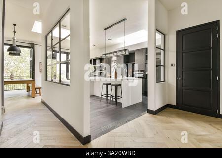 A sleek and contemporary kitchen featuring a minimalist aesthetic with dark cabinetry, light countertops, and an open layout that enhances space and functionality. Stock Photo