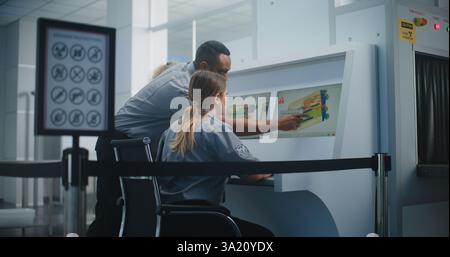 Airport Security Checkpoint: Two Diverse TSA Workers Controlling X-ray Scanning of Suitcase on Computer Monitors Using Modern Program. Advanced Baggage Screening Procedure Technology, Metal Detector. Stock Photo