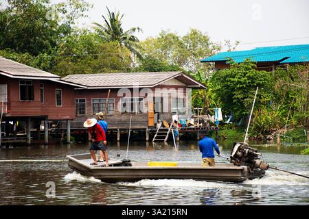 Thai people workers and helmsman long tail boat sailing in Khlong Bangkok Noi Canal keeping trash waste cleaning river at Wat Utthayan temple at Bang Stock Photo