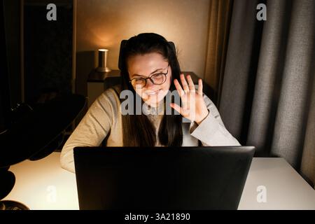 Businesswoman having virtual work meeting using laptop. Freelance worker sitting at home participates in video conference Stock Photo