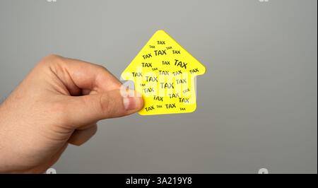 Concept of taxation for real estate and housing. Business and finance. Money, savings. Paper house in the hands of a man Stock Photo