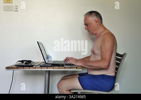 Businessman, freelancer, 60 plus on holiday working with laptop and mobile phone, Pattaya, Chonburi, Thailand, Asia Stock Photo