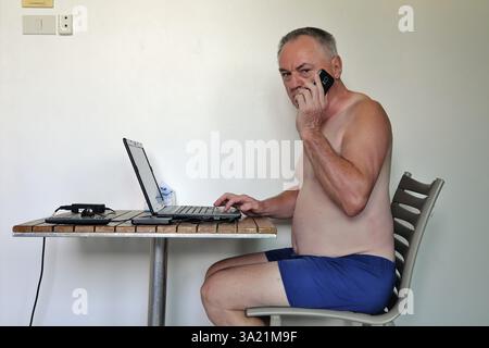 Businessman, freelancer, 60 plus on holiday working with laptop and mobile phone, Pattaya, Chonburi, Thailand, Asia Stock Photo