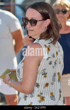 Catania. Italy - March 11, 2025: Female presenter stands with her hand raised, giving an interactive and motivational outdoor talk, fostering connecti Stock Photo