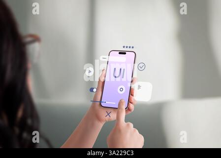 Young woman interacting with smartphone, floating UI elements, user experience and mobile app development concept Stock Photo