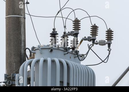 Close up on a power transformer attached to an urban power and lighting pole. Stock Photo
