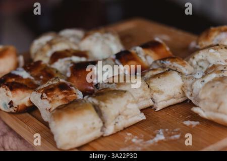 Freshly Baked Garlic Bread Rolls on Wooden Board Stock Photo