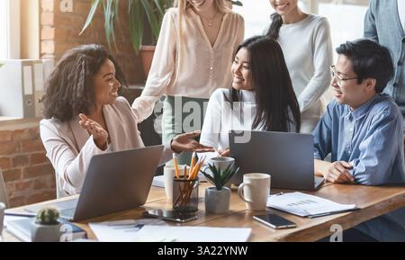 Professional afro woman sharing business ideas with colleagues Stock Photo