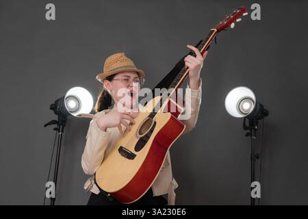 Passionate woman, talented guitarist and singer songwriter, performs with incredible heart and soul. Musician plays guitar, sings country and western Stock Photo