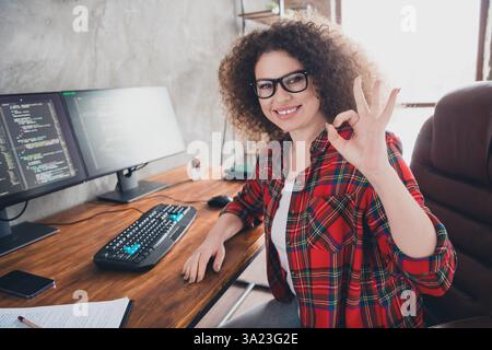 Smiling Female Programmer Gestures in a Comfortable Home Office with Dual Monitors Coding Workspace Stock Photo