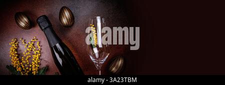 Easter celebration with champagne, mimosa flowers, and eggs Stock Photo