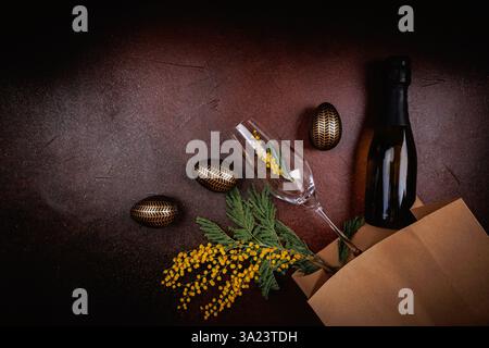 Elegant Easter champagne bottle, flute, and mimosa flowers Stock Photo