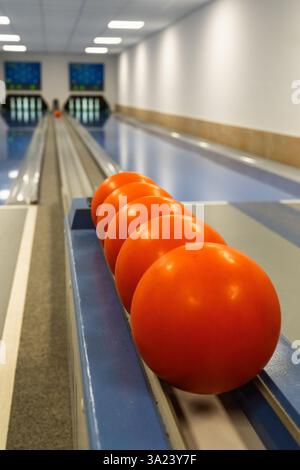 Bowling balls on bowling lane with pins in background. Stock Photo