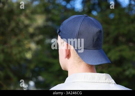 Man in stylish baseball cap outdoors, back view. Mockup for design Stock Photo