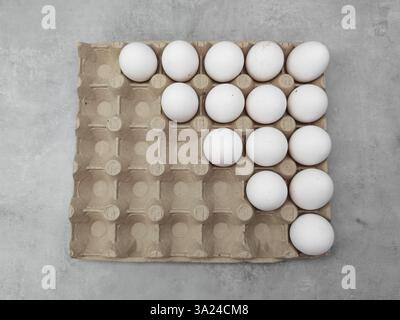White eggs forming an arrow shape in carton on gray background easter Stock Photo