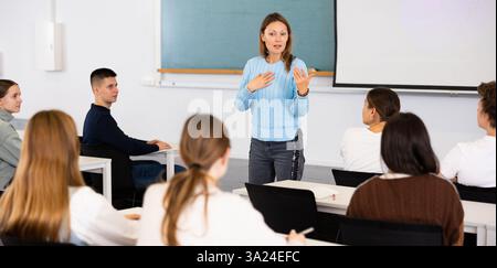 Female professor talks to students in classroom Stock Photo