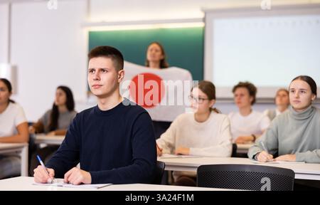 High school teacher tells students about Japan and holds a Japanese flag in hands. Stock Photo