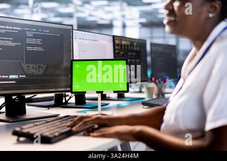 Programmer using green screen tablet to check for signs of failure in data center supercomputers. Woman working on mockup device to prevent damages in server farm, monitoring systems Stock Photo