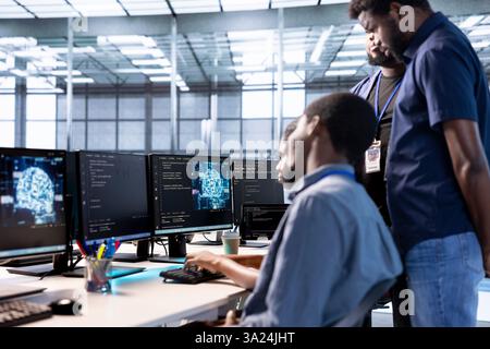 Admin doing brainstorming with colleagues in server farm, using artificial intelligence technology for increased productivity. Team of data center coworkers implementing AI driven solutions Stock Photo