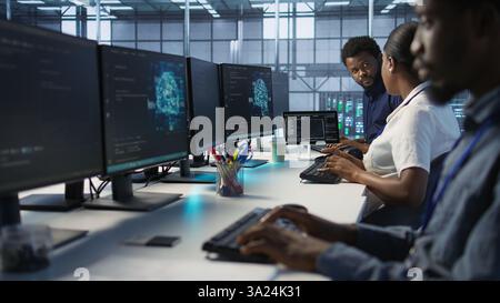 IT specialists in data center doing brainstorming, maintaining company network infrastructure. Team of server hub computer scientists chatting, ensuring optimal system performance, camera A Stock Photo