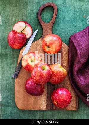 Whole and sliced apples on a wooden board Stock Photo