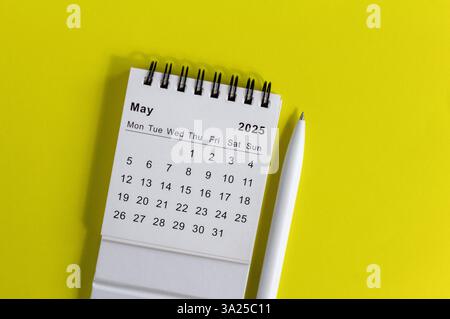 Hello, May 2025 desk calendar for planning on yellow background Stock Photo