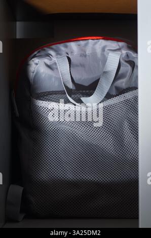 A gray bag is stored in the bookshelf Stock Photo