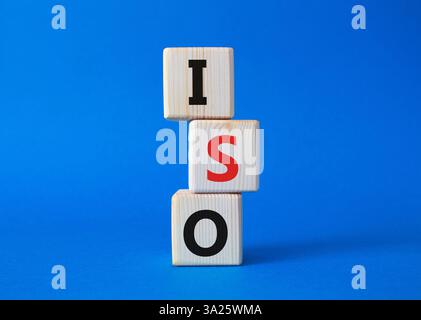 ISO standards quality control symbol. Concept word ISO on wooden cubes. Beautiful blue background. Business and ISO concept. Copy space. Stock Photo