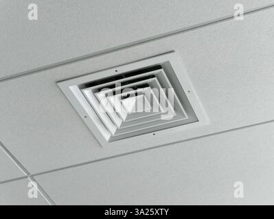 Ceiling socket for the ventilation duct of a cooling and heating system for large rooms, installed on a suspended ceiling. HVAC system Stock Photo