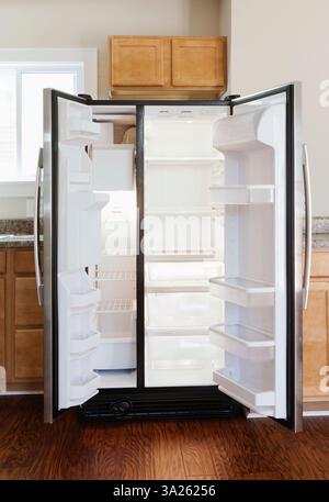 An open stainless steel double door refrigerator in kitchen. Stock Photo