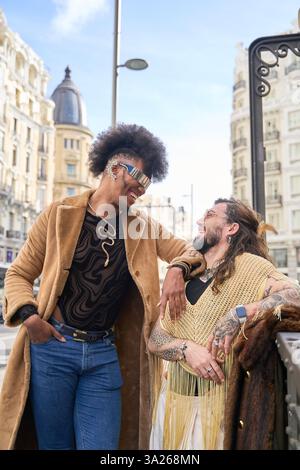 Two androgynous non binary people wearing modern clothes are enjoying a day together in the city Stock Photo