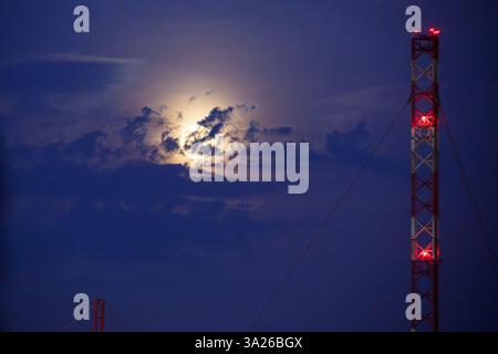 Lunar eclipse at dusk with transmission tower Stock Photo