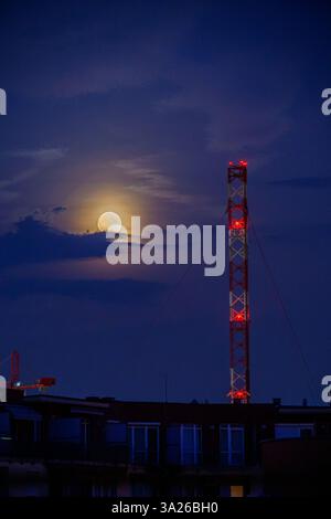 Lunar eclipse at dusk with transmission tower Stock Photo