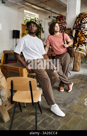 Two handsome men enjoy each others company while sitting in a charming cafe filled with art. Stock Photo