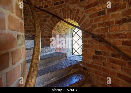 Window niche by the stairs in an old tower of bricks Stock Photo