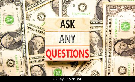Ask any questions symbol. Concept words Ask any questions on beautiful wooden blocks. Dollar bills. Beautiful background from dollar bills. Business a Stock Photo