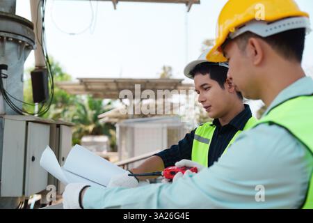 Sustainable Solutions and Renewable Energy Installation. Technicians working together on solar energy equipment at a renewable project site. Stock Photo