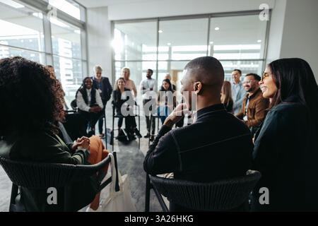 Multiethnic employees participating in an interactive workshop within a modern office environment, fostering teamwork and collaboration. Stock Photo