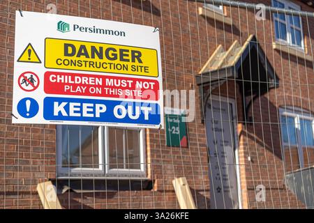 Persimmon house builders sign on a building site fence explaining that this is a danger, construction site area and to keep out. Stock Photo