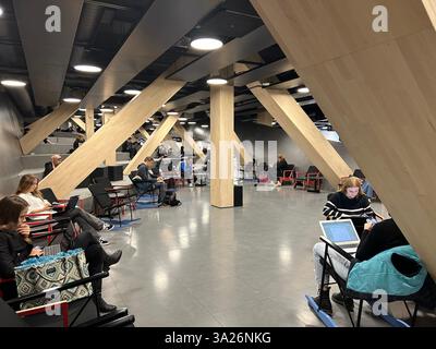 University students from studying on laptops on the first floor of the Oodi Library, Helsinki, Finland Stock Photo