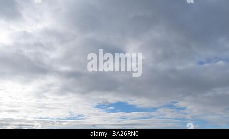 Fluffy clouds covering a morining blue sky Stock Photo
