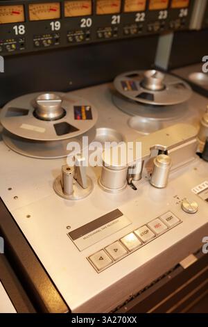 Close-up of a vintage audio tape recorder with reels and control buttons in a recording studio. Stock Photo